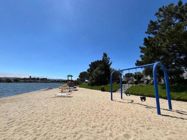 surrounding community with a playground and a water view