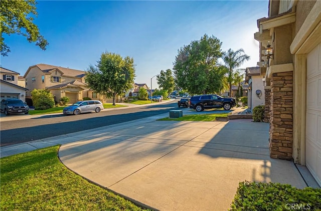 view of street featuring a residential view and concrete driveway