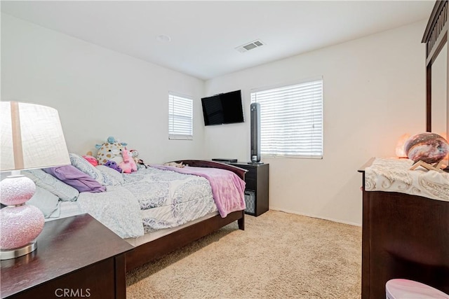 bedroom featuring light colored carpet and visible vents