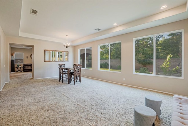 dining space with light carpet, a chandelier, radiator, and a tray ceiling