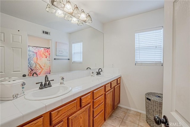 full bathroom with double vanity, tile patterned flooring, visible vents, and a sink