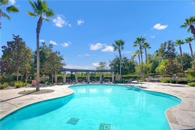 community pool with a patio, fence, and a pergola