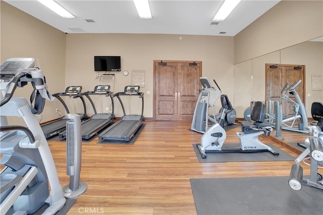 workout area with light wood-style flooring and visible vents