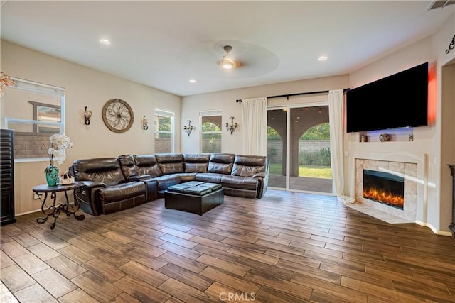 living room featuring recessed lighting, a fireplace, visible vents, and wood tiled floor