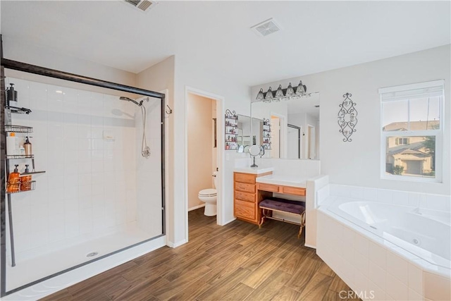 full bathroom with toilet, wood finished floors, visible vents, a bath, and a stall shower