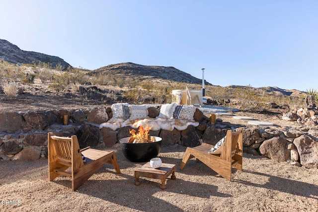 view of yard with a mountain view and an outdoor fire pit