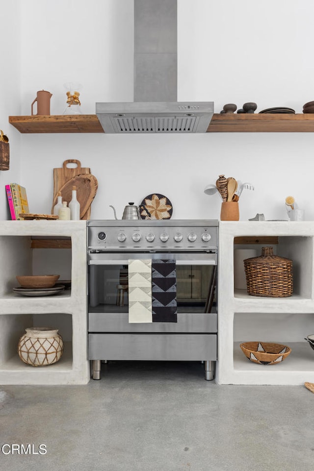 interior space featuring stainless steel range, wall chimney range hood, and concrete floors