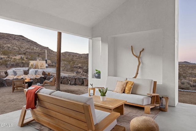 living room with concrete floors, lofted ceiling, and a mountain view