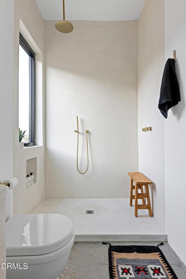 bathroom featuring walk in shower and toilet