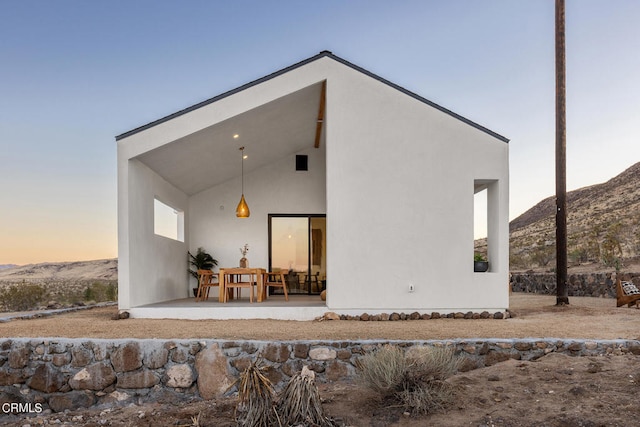 back house at dusk with a patio