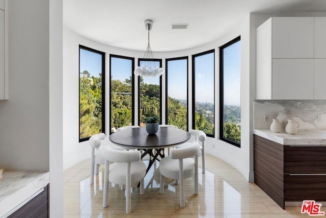 dining room with plenty of natural light, a notable chandelier, and light tile patterned flooring