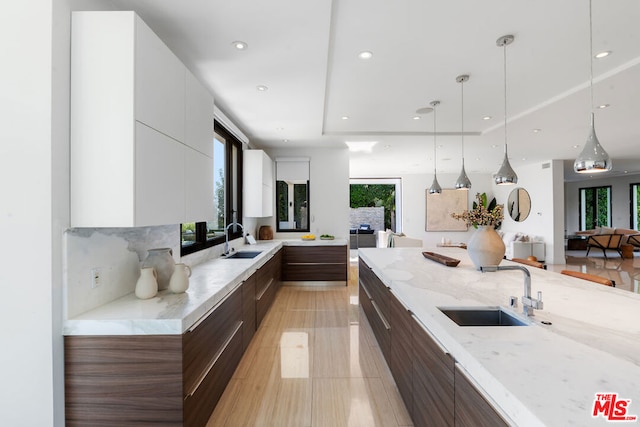 kitchen with pendant lighting, a healthy amount of sunlight, and sink