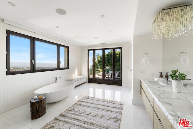 bathroom with french doors, vanity, a wealth of natural light, and a bathing tub