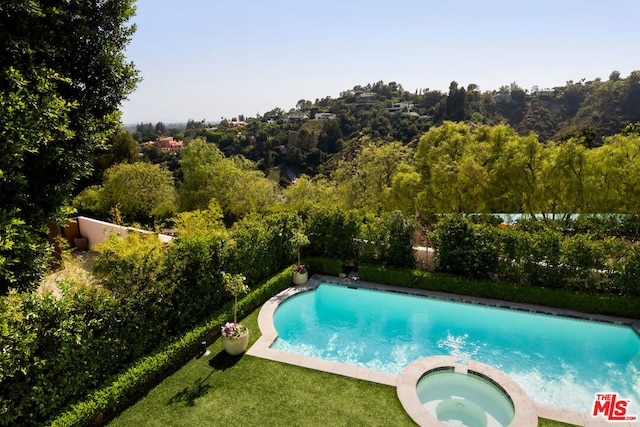 view of swimming pool featuring an in ground hot tub and a lawn