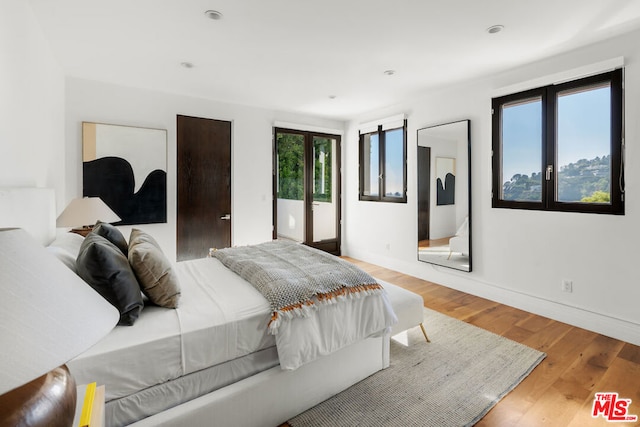 bedroom featuring multiple windows and light hardwood / wood-style floors