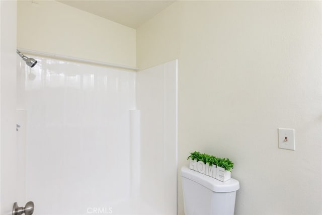 bathroom featuring a shower and toilet