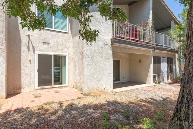 back of house featuring a balcony and a patio area