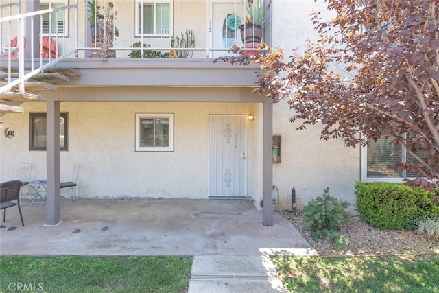 entrance to property featuring a balcony and a patio area