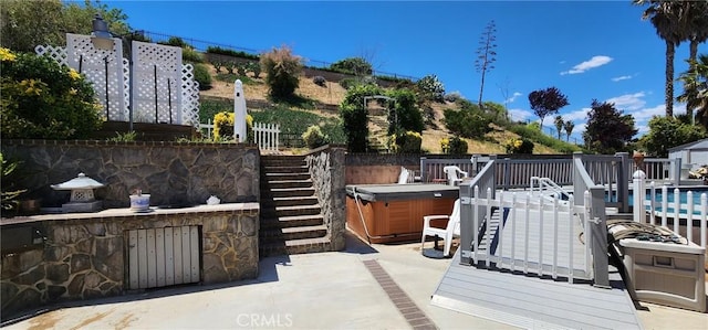 view of patio / terrace with a swimming pool with hot tub