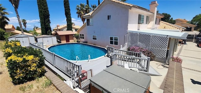 view of swimming pool featuring a storage unit and a wooden deck