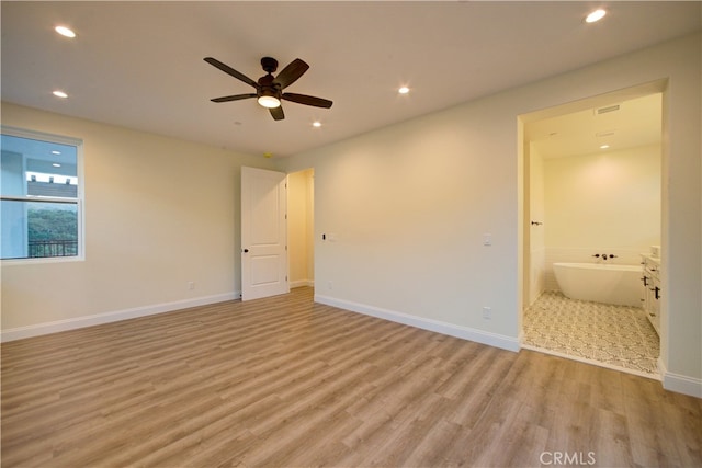 unfurnished bedroom with ceiling fan, ensuite bath, and light hardwood / wood-style floors