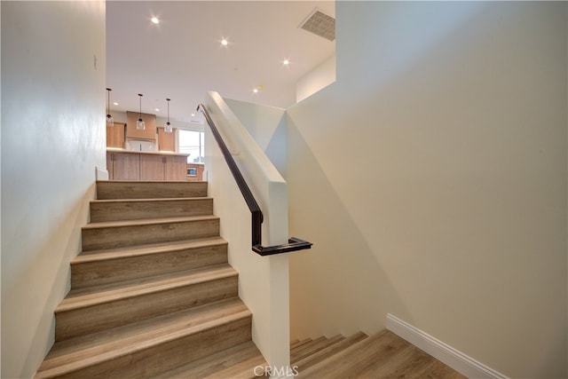 stairs featuring hardwood / wood-style floors