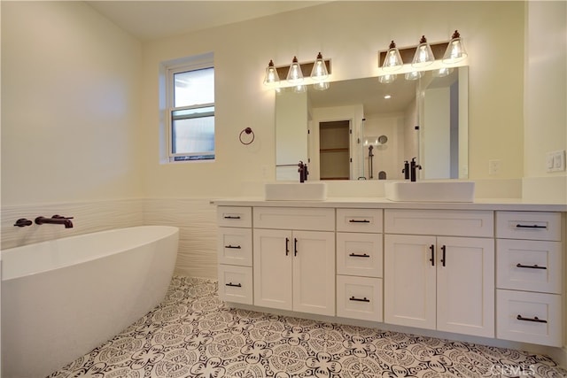 bathroom with tile walls, a tub to relax in, vanity, and tile patterned floors