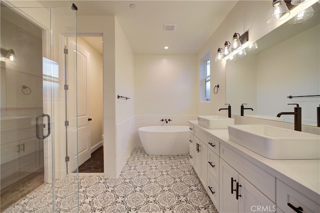 bathroom featuring vanity, tile walls, shower with separate bathtub, and tile patterned flooring