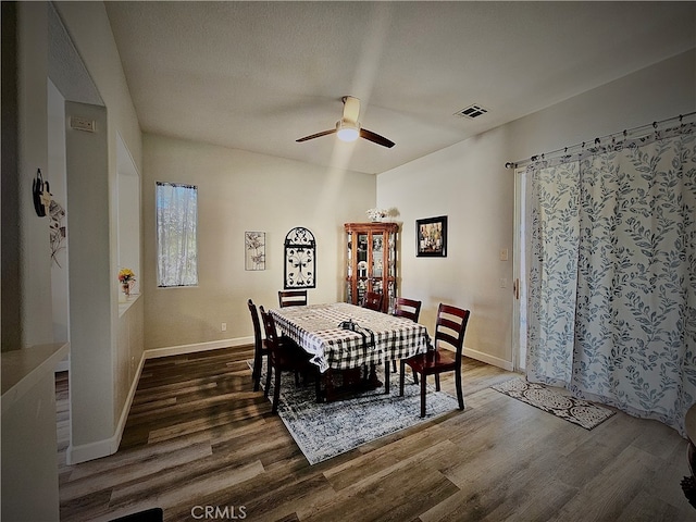 dining area with ceiling fan, a textured ceiling, and dark hardwood / wood-style floors