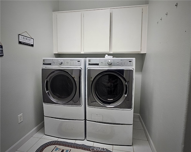 laundry room with light tile patterned floors, cabinets, and independent washer and dryer