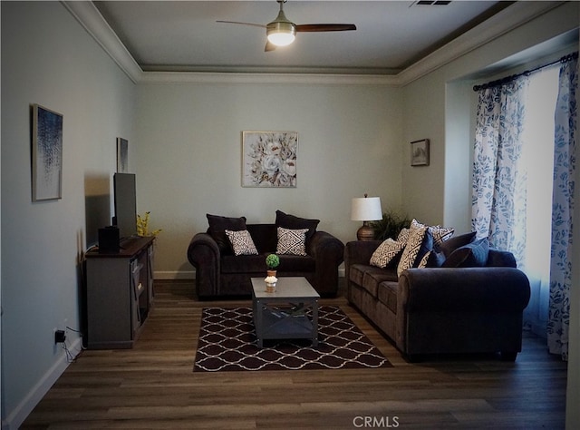 living room with ornamental molding, dark wood-type flooring, and ceiling fan