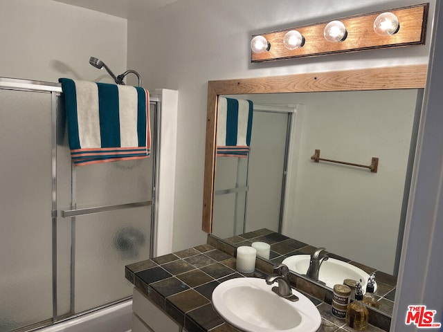 bathroom with a shower with door and vanity