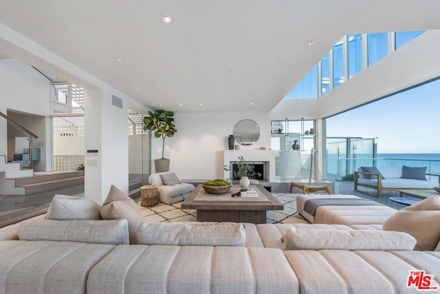 living room with a towering ceiling and a water view