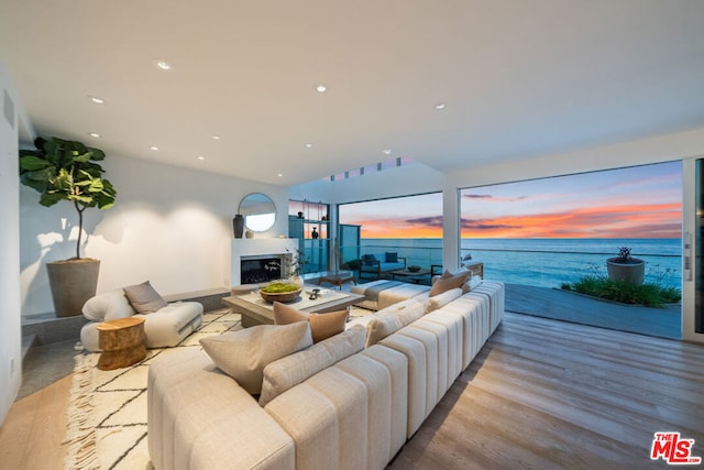 living room featuring a water view and light hardwood / wood-style flooring