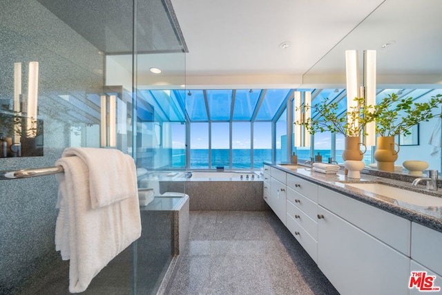 bathroom featuring vanity, a water view, a bathtub, and a wealth of natural light