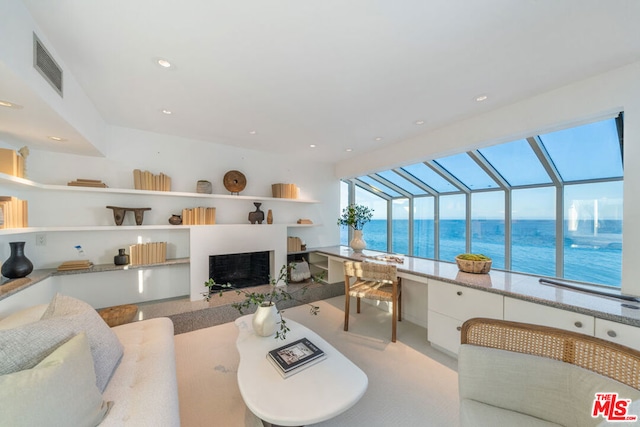 living room featuring a water view and light colored carpet