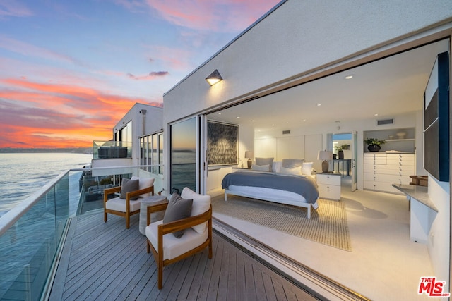 carpeted bedroom with a water view