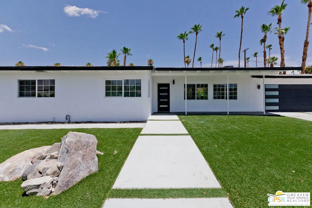 view of front of home featuring a front yard and a garage