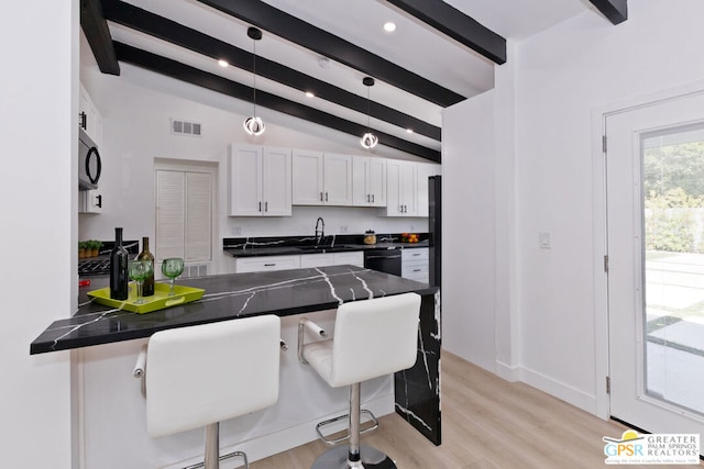 kitchen with pendant lighting, a breakfast bar, kitchen peninsula, vaulted ceiling with beams, and white cabinetry