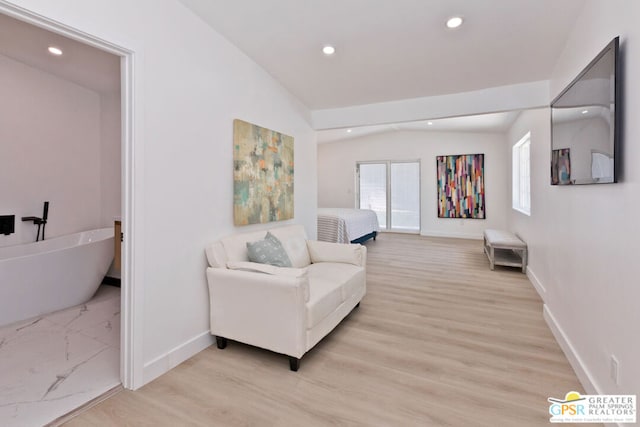 sitting room with light hardwood / wood-style flooring and vaulted ceiling