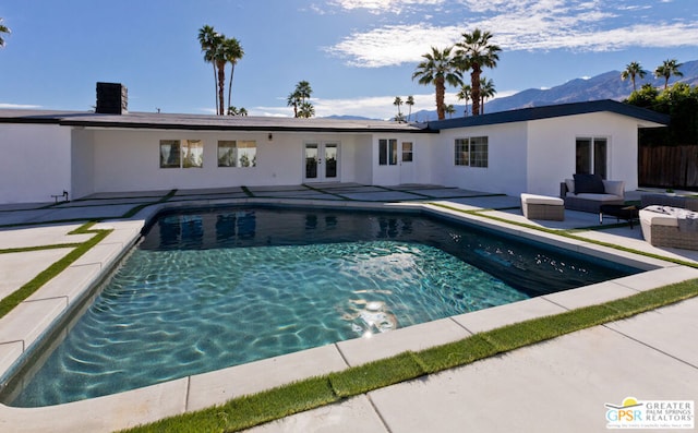 view of swimming pool with a mountain view, french doors, an outdoor hangout area, and a patio