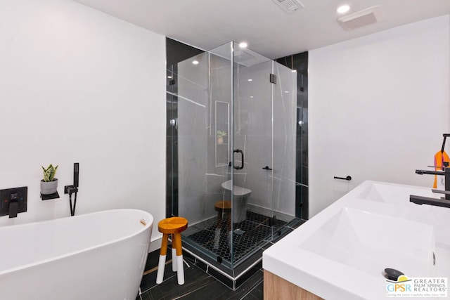 bathroom featuring plus walk in shower, vanity, and tile patterned flooring