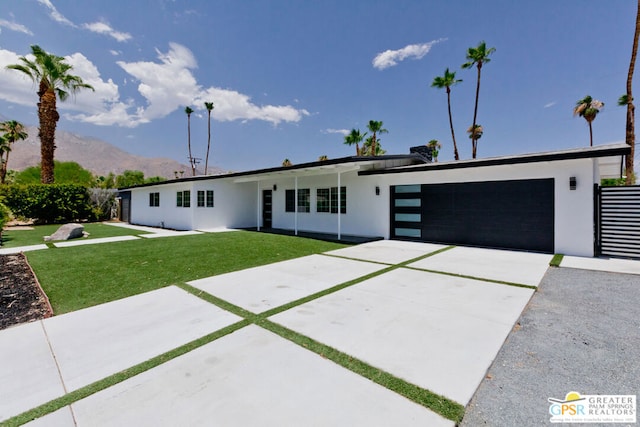 view of front of home featuring a mountain view, a garage, and a front yard