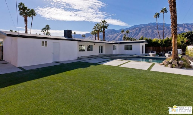 back of house featuring a mountain view and a yard