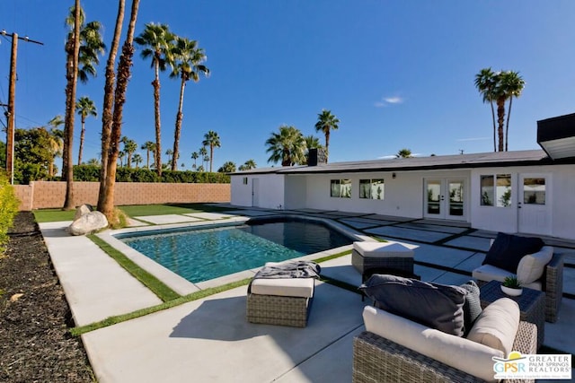 view of pool featuring a patio area, an outdoor living space, and french doors