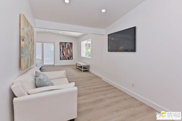 living room with light hardwood / wood-style floors and vaulted ceiling