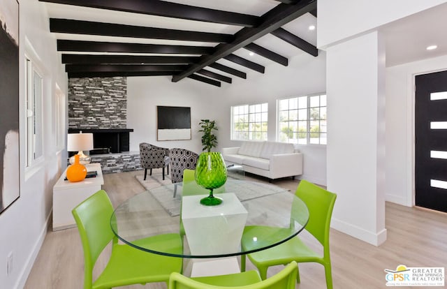 dining space with vaulted ceiling with beams and light wood-type flooring