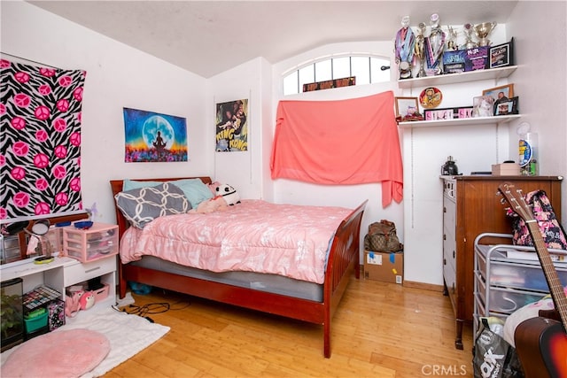 bedroom with lofted ceiling and hardwood / wood-style floors