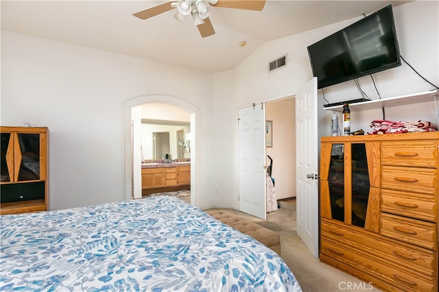 carpeted bedroom featuring ceiling fan, lofted ceiling, and ensuite bathroom