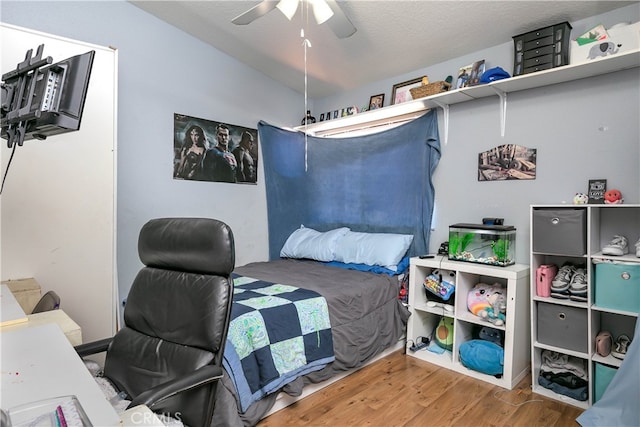 bedroom with wood-type flooring, a textured ceiling, and ceiling fan